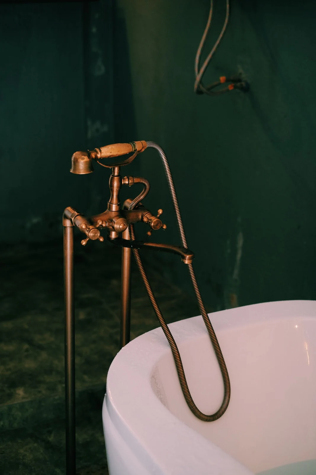 Vintage brass faucet and bathtub in dimly lit bathroom. Stylish and classic design
