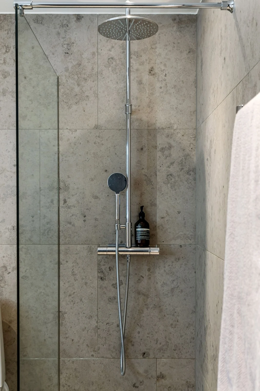 Contemporary shower area with gray tiles and minimalist design featuring glass enclosure