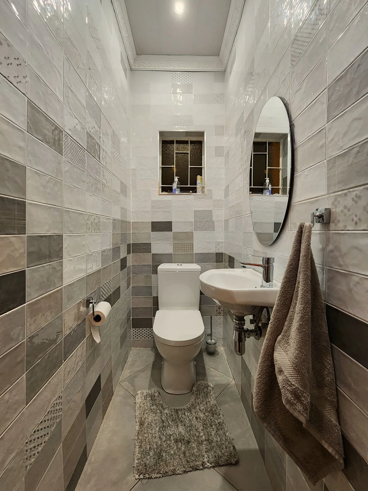 A sleek and contemporary bathroom with stylish tiled walls and modern fixtures