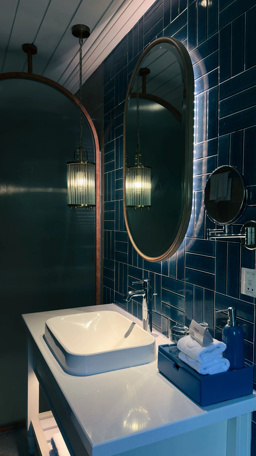Bathroom basin below an oval mirror