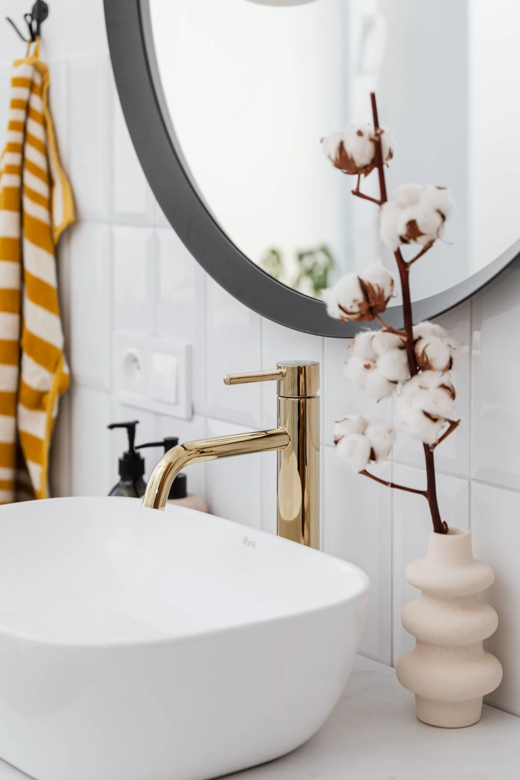 Bathroom basin below a round mirror