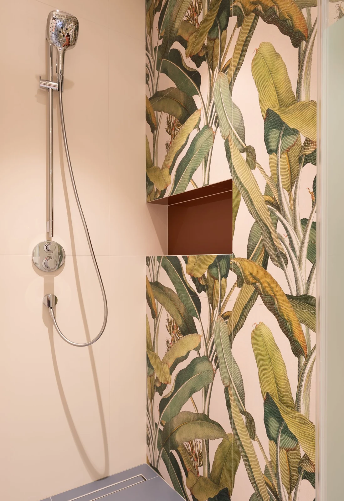 Interior of modern light bathroom with shower on tile near colorful wall with shelf