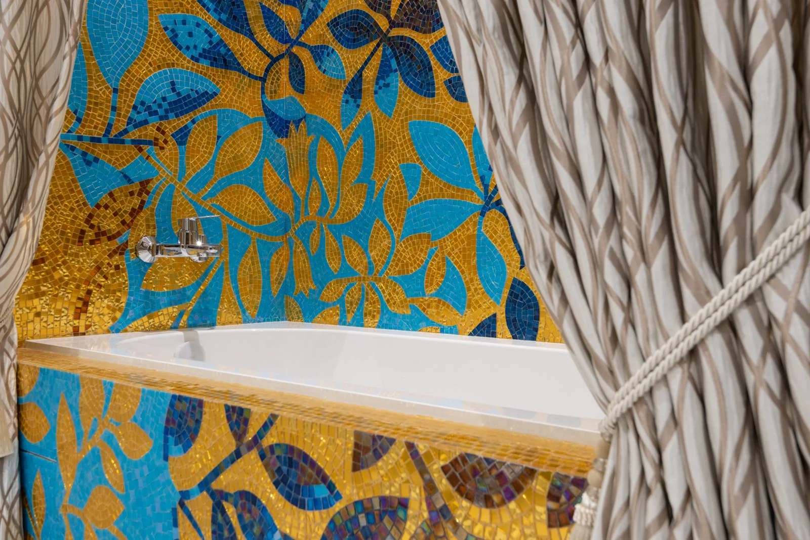 Vibrant bathtub design with floral mosaic tiles and stylish curtains