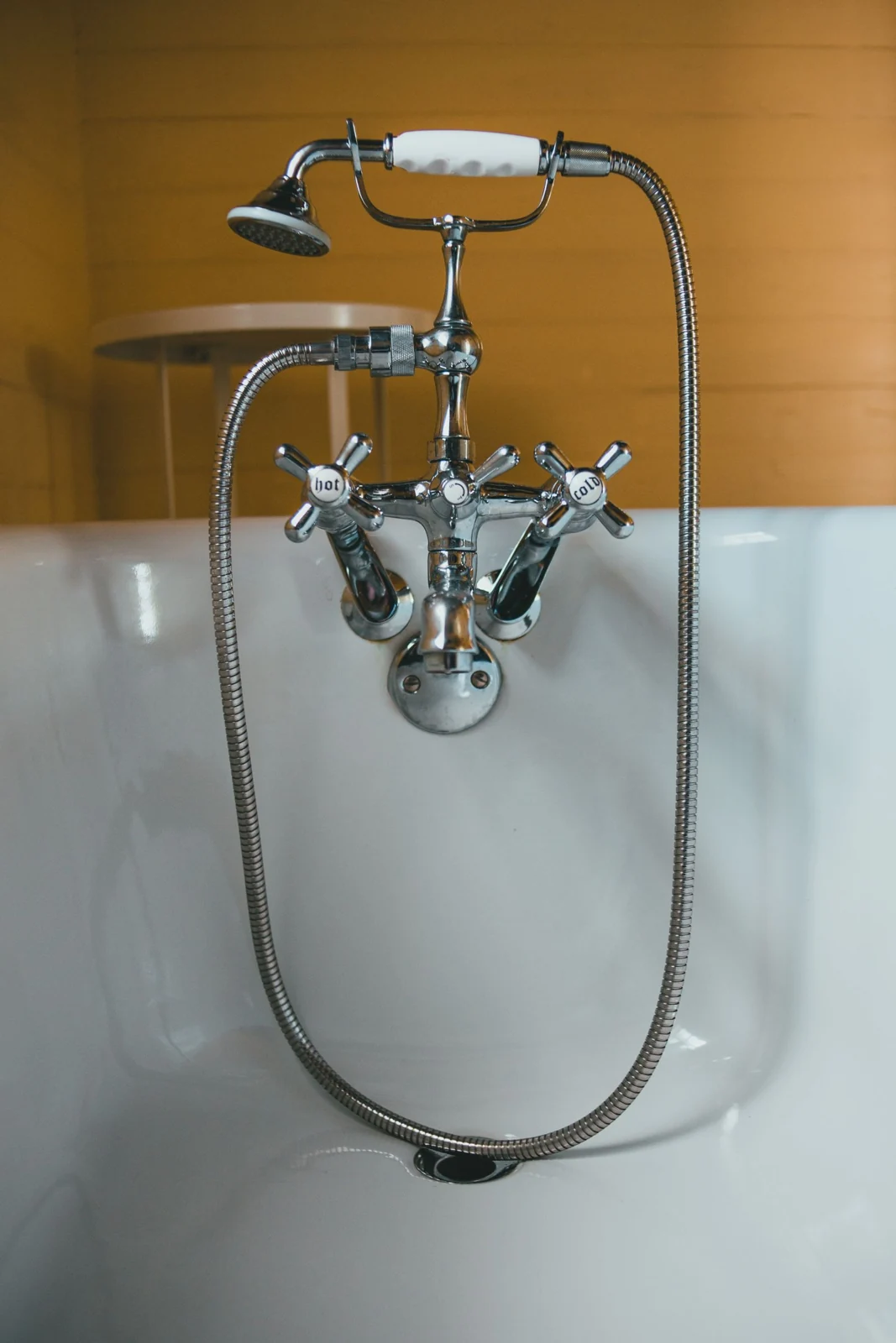 Elegant chrome vintage faucet and shower head in a white bathtub